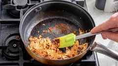 Palaneen kattilan pohjaa kaavitaan lastalla liedellä